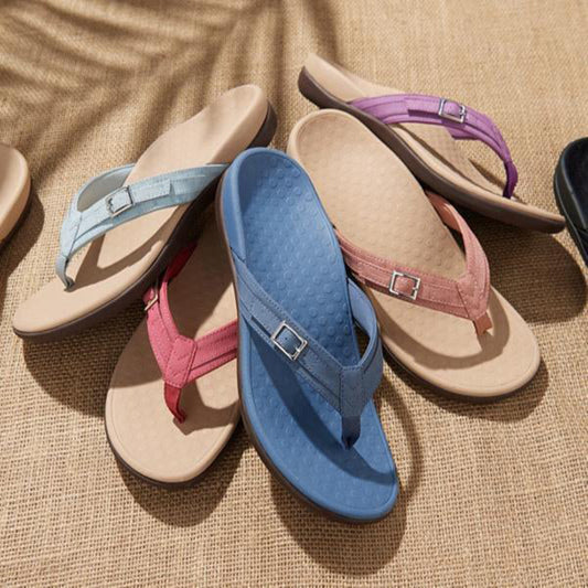 A collection of orthopedic sandals in various colors displayed on a textured surface.
