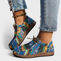 Colorful patterned shoes worn with rolled-up jeans on a light background